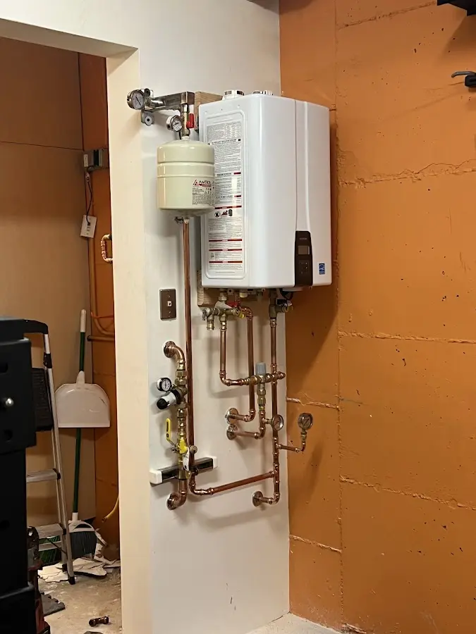 Plumbing technician inspecting water heater connections in Bostonia